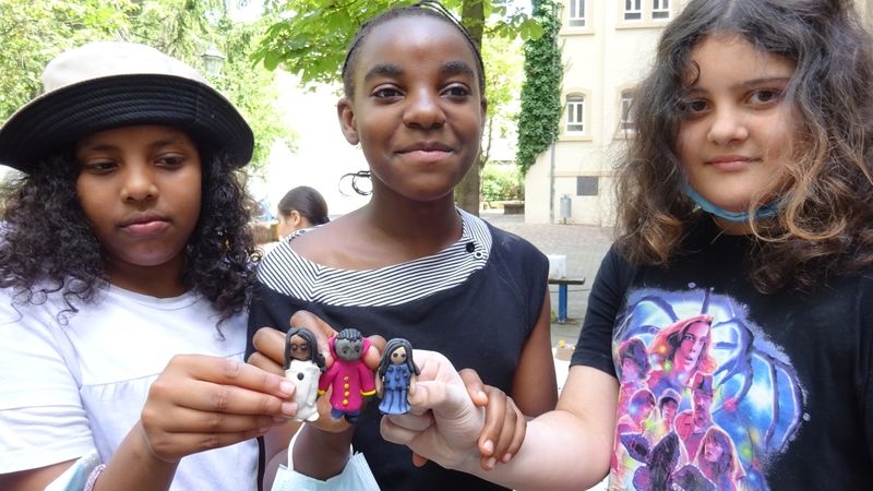 Drei Klimaheldinnen der Hans-Thoma-Schule in Karlsruhe zeigen ihre Klimaheldinnen-Figuren.