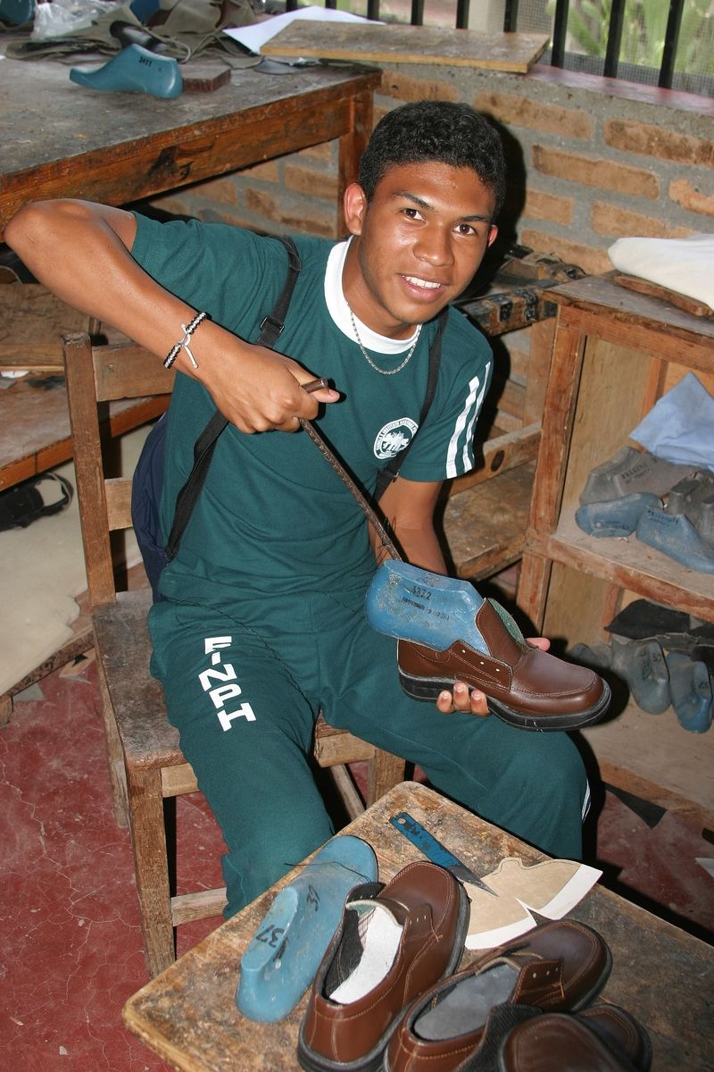 Ein Schüler fertigt in seinem Workshop Schuhe für die nph-Kinder.