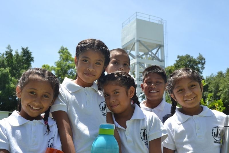 Mexikanische Schülerinnen und Schüler vor dem neugebauten Wasserturm.