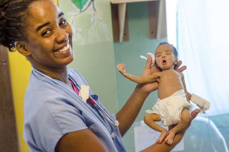 Eine nph-Krankenschwester in Haiti mit einem Frühchen.